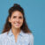 Portrait of young beautiful woman with curly hair smiling at camera isolated on blue background